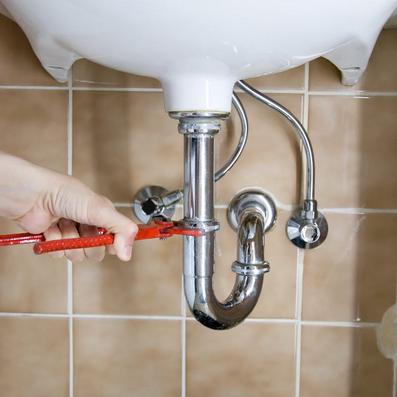 plumber-tightening-pipe-under-basin
